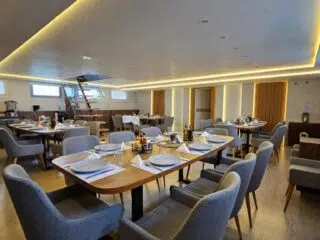 Nowoczesna, jasna restauracja z elegancko nakrytymi stołami - idealne miejsce na relaks po wyjeździe kitesurfingowym z KiteAway.