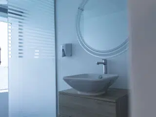 Nowoczesna łazienka z matowym szkłem, idealna na relaks po wyjazdach kitesurfingowych z KiteAway; dużo naturalnego światła.