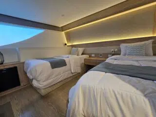 Dwa łóżka pojedyncze w jasnym, nowoczesnym pokoju - idealne na relaks po kursie kitesurfingu czy kite camp z KiteAway.