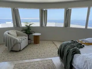 Minimalistyczna sypialnia z widokiem na ocean - idealna na relaks po wyjazdach kitesurfingowych z KiteAway.