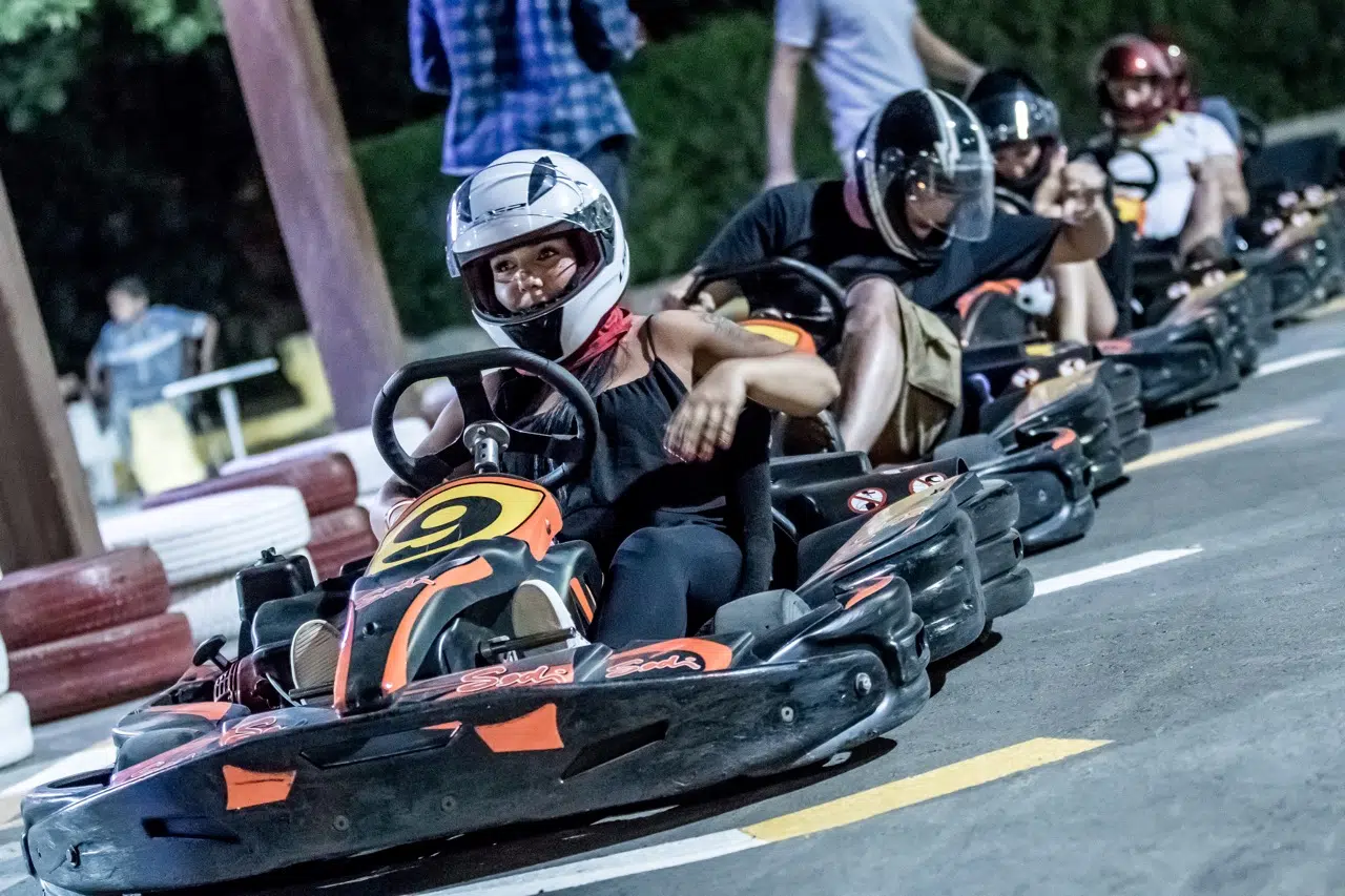 Grupa osób w kaskach na gokartach czeka na start wyścigu, klimatyczna atrakcja podczas wyjazdu kitesurfingowego El Gouna.