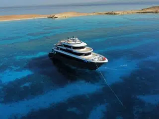 Luksusowy jacht na turkusowej wodzie blisko plaży i rafy - idealne miejsce na wyjazdy kitesurfingowe z KiteAway.