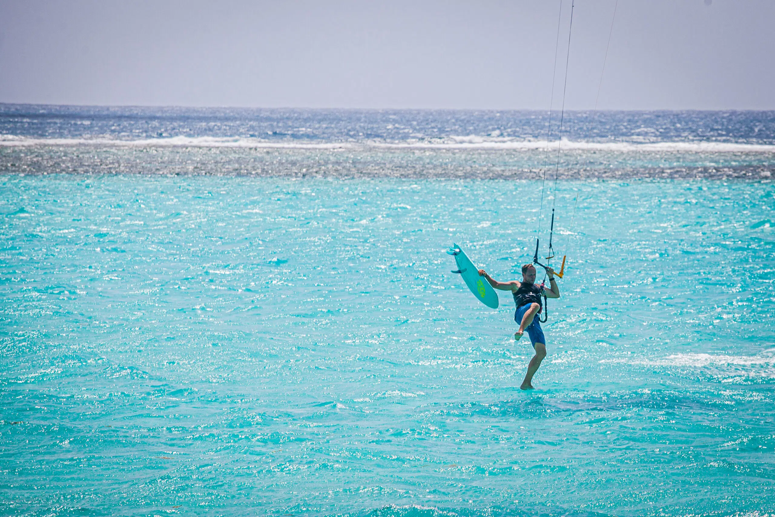 Kitesurfer unosi się nad turkusową wodą w trakcie wyjazdu KiteAway - wakacje z kitesurfingiem, kurs kitesurfingu, Karaiby.