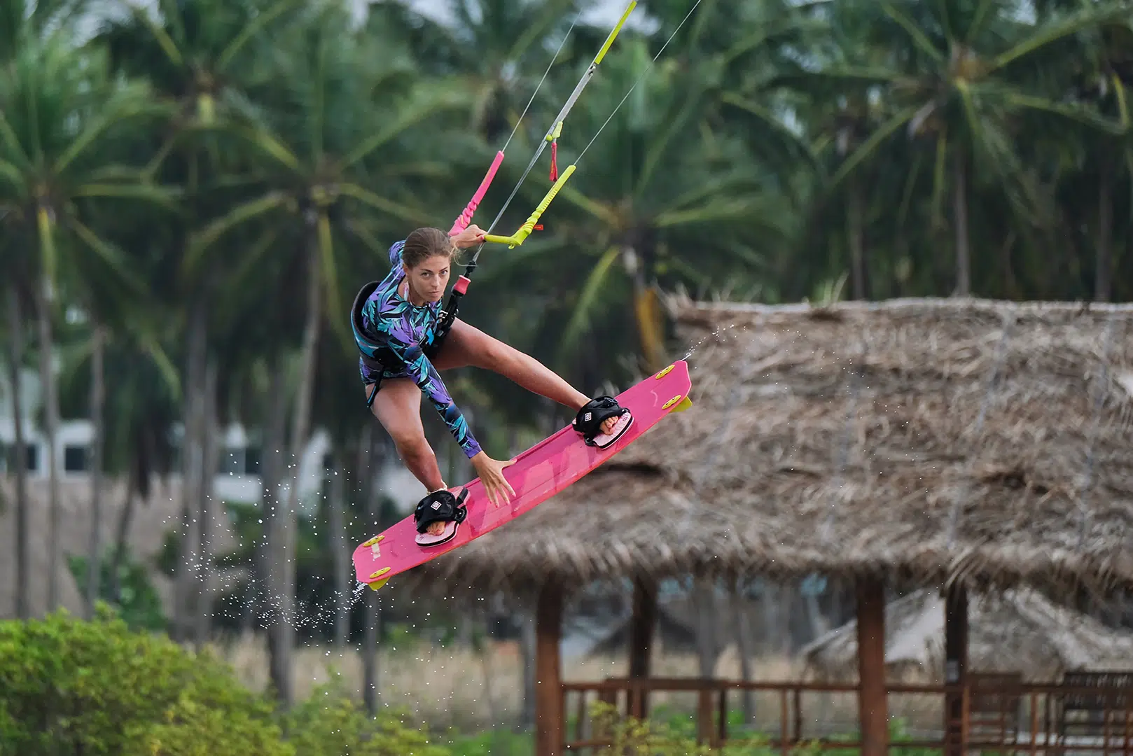 Kitesurfer w kolorowej piance wykonuje trik na Sri Lance - idealne miejsce na wyjazdy kitesurfingowe z KiteAway.pl.