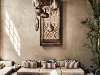 Jasny salon z beżową sofą i rośliną, pełen światła jak apartament na wyjazd kitesurfingowy KiteAway - klimat El Gouna.