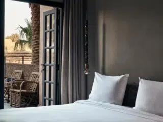 Przytulna, nowoczesna sypialnia idealna na relaks po wyjeździe kitesurfingowym El Gouna z KiteAway, widok na palmowe patio.