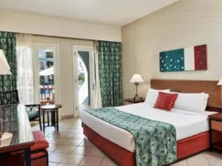 Nowoczesny pokój hotelowy z balkonem, idealny na relaks po dniu pełnym emocji podczas wyjazdu kitesurfingowego z KiteAway.