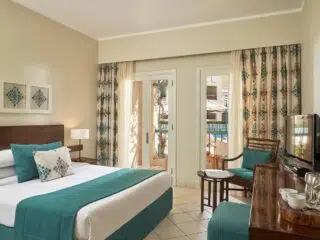 Nowoczesny pokój hotelowy z podwójnym łóżkiem, biurkiem i patio - idealny na relaks po szkoleniu latawców w El Gounie z KiteAway.