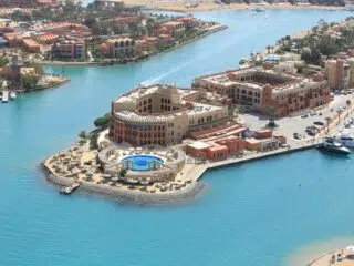 Widok z lotu ptaka na resort przy plaży - basen, plażowe parasole, jachty i turkusowa woda; idealny kite spot KiteAway.