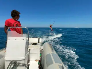 Emocje na kite trip w El Gouna - szkolenie kitesurfingu z KiteAway na tle lazurowej wody i słonecznego, bezchmurnego nieba.
