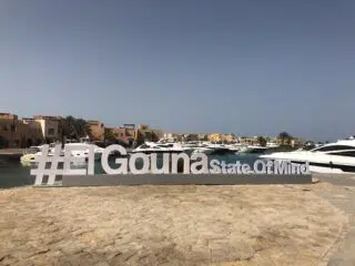 Duży biały napis #ElGouna State Of Mind przy marinie, luksusowe jachty i kolorowe budynki - idealny klimat na wyjazdy kitesurfingowe.