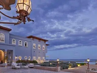 Nadmorski hotel z niebieskimi ścianami i łukowatymi oknami, idealny na relaks po szkoleniu kite w El Gounie z KiteAway.