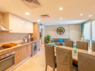 Nowoczesna kuchnia i salon z turkusową sofą, idealne wnętrze na relaks po kursie kitesurfingu z KiteAway lub kite camp.