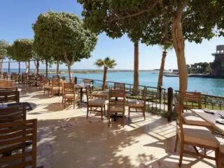 Taras restauracji nad rzeką z widokiem na palmy - idealne miejsce na relaks po wyjazdach kitesurfingowych z KiteAway.