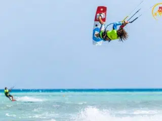 Kiteboarder wykonuje efektowny trick nad turkusową wodą El Gouna - idealny spot na wyjazdy kitesurfingowe z KiteAway.