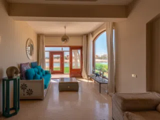 Jasny salon z niebieską sofą i dużymi oknami, idealny na relaks po wyjazdach kitesurfingowych z KiteAway.