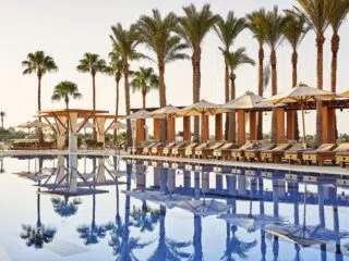 Basen otoczony palmami i leżakami, idealny na relaks po kursie kitesurfingu lub kite camp z KiteAway.