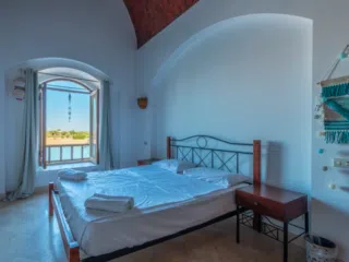 Jasna sypialnia z dużym łóżkiem i widokiem na rzekę-idealna na relaks po dniu na kite campie KiteAway, wyjazdy kitesurfingowe.