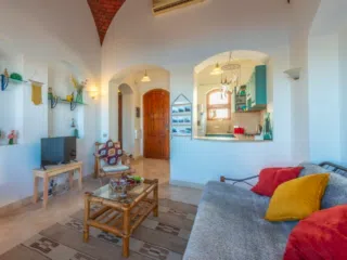 Przytulny salon po wyjeździe kitesurfingowym z KiteAway, bambusowy stolik, widok na kuchnię-idealny relaks po kite tripie.