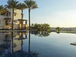 Basen z palmami i nowoczesnym budynkiem o zachodzie słońca, El Gouna - idealne miejsce na wyjazdy kitesurfingowe z KiteAway.