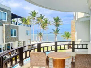 Balkon z widokiem na palmowy kite spot i plażę, idealny na relaks po kursie kitesurfingu z KiteAway lub udanym kite tripie.