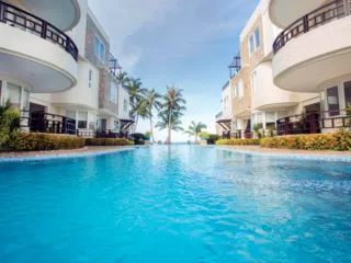 Basen KiteAway otoczony palmami i białymi budynkami z widokiem na ocean-idealny relaks po wyjazdach kitesurfingowych.