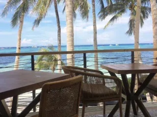 Strefa relaksu z widokiem na plażę, palmy i morze - idealne miejsce po wyjeździe kitesurfingowym z KiteAway.