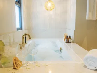 Relaks w luksusowej wannie z bąbelkami po dniu na kite camp KiteAway - ręczniki, wino, kosmetyki na wyjazdy kitesurfingowe.