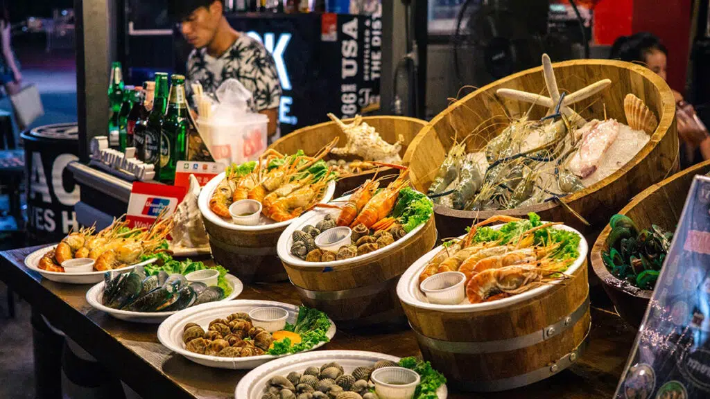 Świeże owoce morza na straganie - idealne po dniu na kite camp z KiteAway. W tle butelki i postać. Świeże owoce morza na straganie - idealne po dniu na kite camp z KiteAway. W tle butelki i postać.