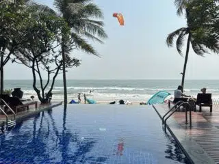 Relaks przy basenie infinity z widokiem na plażę i kitesurfera - idealny kite trip z KiteAway, wakacje z kitesurfingiem.