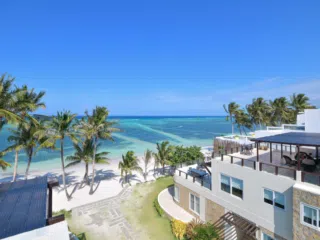 Biały resort nad morzem z palmami i plażą - idealne miejsce na wyjazdy kitesurfingowe z KiteAway, kite spot z doskonałymi warunkami.