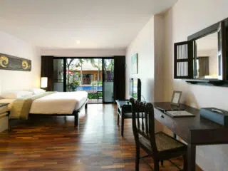 Przestronny pokój hotelowy z balkonem i widokiem na basen - idealne miejsce na relaks podczas wyjazdu kitesurfingowego KiteAway.