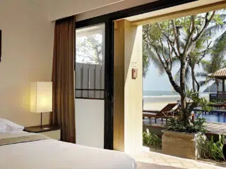 Jasny pokój hotelowy z widokiem na basen, palmy i ocean - idealny na wypoczynek po wyjazdach kitesurfingowych z KiteAway.