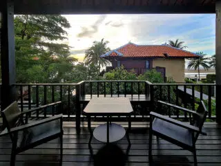 Zacieniony taras z widokiem na zieleń i palmy - idealne miejsce na relaks podczas wyjazdu kitesurfingowego z KiteAway.