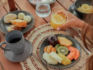 Śniadanie przed wyjazdem na kite camp: owoce, wędliny, kawa i sok na stole - idealny start dnia z KiteAway i wakacje z kitesurfingiem.