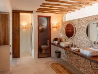 Rustykalna łazienka z kamiennymi ścianami, akcentami z drewna-komfort na wyjazdy kitesurfingowe KiteAway, kite camp.