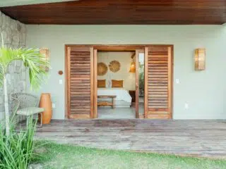 Przytulny bungalow na kite camp KiteAway, z tarasem, kwiatami i widokiem na łóżko - idealny na wyjazdy kitesurfingowe.