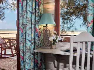 Przytulny pokój nad morzem idealny na relaks po KiteAway wyjazdy kitesurfingowe; widok na plażę, niebo i kite spot za oknem.