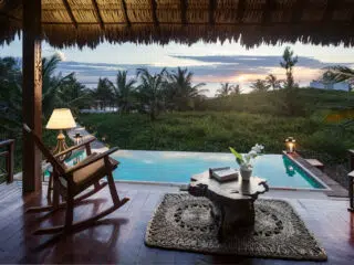 Zadaszony taras z widokiem na basen i palmy, idealny na relaks po dniu kursu kitesurfingu z KiteAway - wakacje z kitesurfingiem.