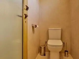 Kompaktowa łazienka z beżowymi płytkami - idealna na odświeżenie po KiteAway wyjazdy kitesurfingowe lub kite camp.