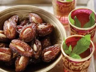 Dekoracyjna miska z daktylami i mięta herbata - idealna przekąska po kursie kitesurfingu z KiteAway lub udanym kite tripie.