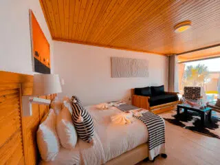 Nowoczesny pokój hotelowy z drewnianym sufitem, idealny na relaks po kite camp KiteAway - doskonała baza na wyjazdy kitesurfingowe.