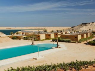 Luksusowy ośrodek z drewnianymi willami i basenem, idealny na wyjazdy kitesurfingowe KiteAway, tuż przy niebieskiej lagunie.