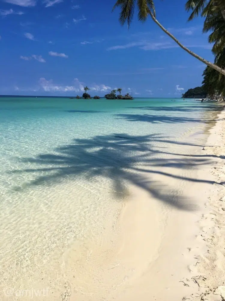 Plaża z białym piaskiem, palmami i turkusową wodą - idealny spot na wyjazdy kitesurfingowe KiteAway i wakacje z kitesurfingiem.