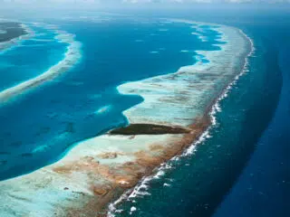 Turkusowa rafa i atol w głębokim oceanie-idealne miejsce na wyjazdy kitesurfingowe i kite camp z KiteAway pod błękitnym niebem.