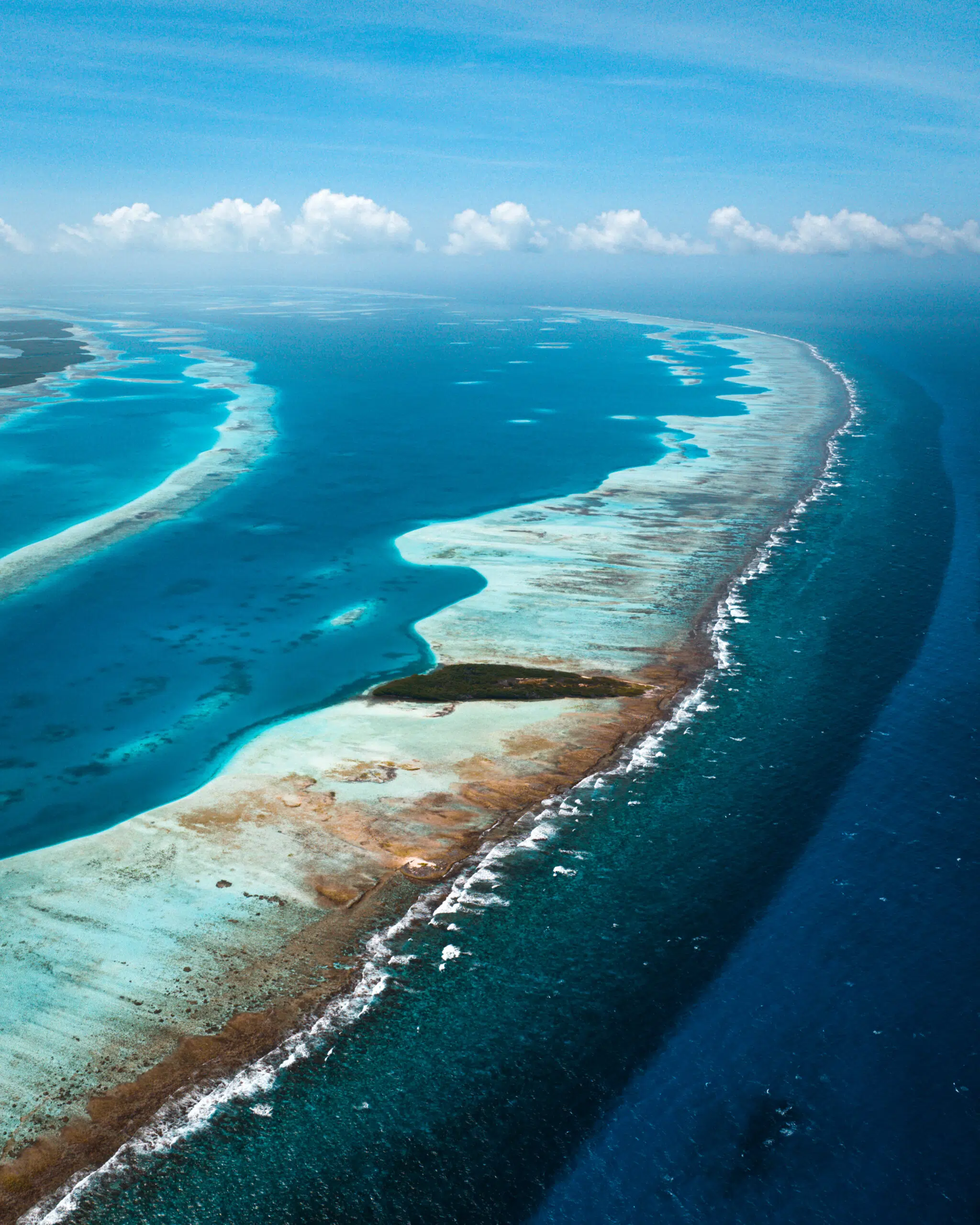 Turkusowa rafa i atol w głębokim oceanie-idealne miejsce na wyjazdy kitesurfingowe i kite camp z KiteAway pod błękitnym niebem.