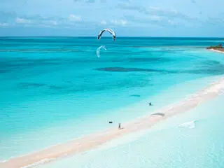 Turkusowa woda, piaszczysta plaża i dwóch kitesurferów - idealne miejsce na wyjazdy kitesurfingowe z KiteAway lub kurs kitesurfingu.