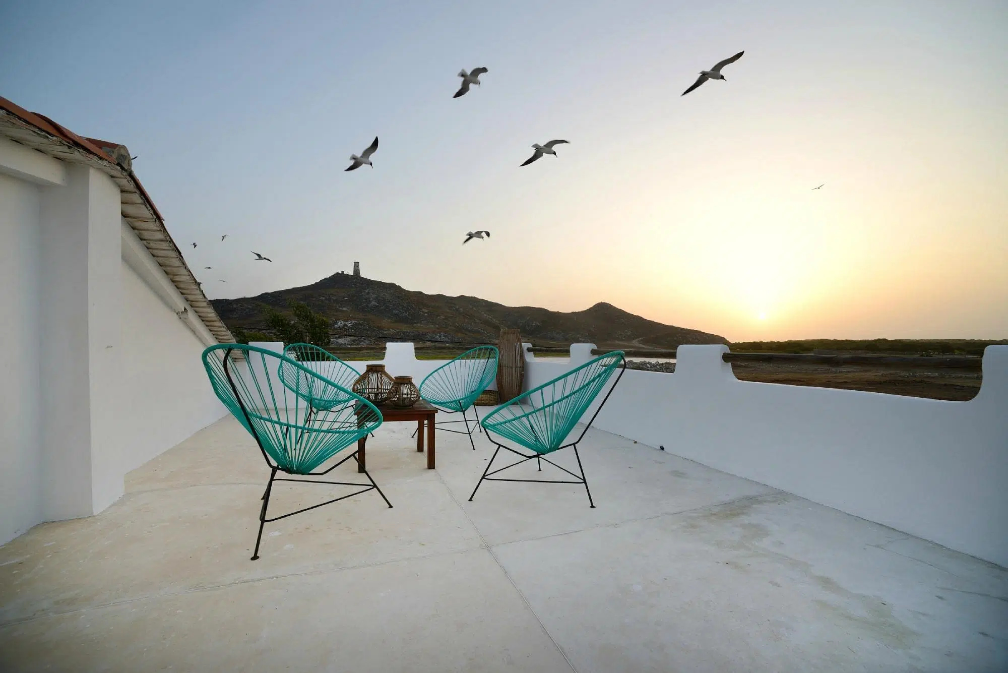 Taras na dachu z turkusowymi krzesłami i stolikiem - idealny relaks po kursie kitesurfingu lub kite camp z KiteAway.pl.