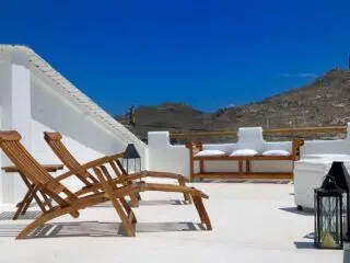 Słoneczny taras na dachu z leżakami i widokiem na wzgórza - idealny relaks po dniu na wyjeździe kitesurfingowym KiteAway.