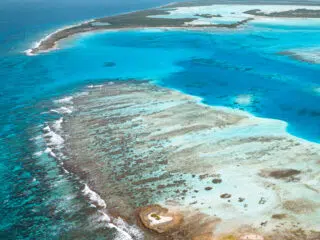 Lotnicze ujęcie turkusowej rafy i płycizn - idealny spot na wyjazdy kitesurfingowe KiteAway, otoczony lazurowym morzem.